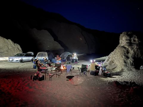 Camp in Painted Canyon after dark: headlamps, camp dinner, and singing under the stars