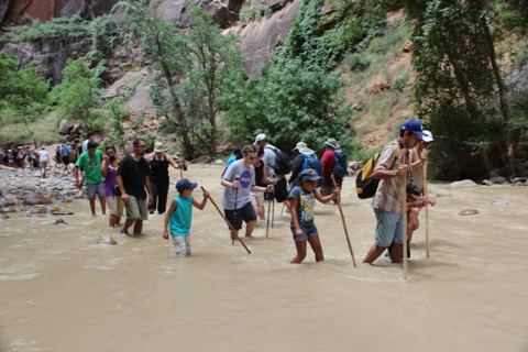 Kids included: the whole group wading upstream with walking sticks